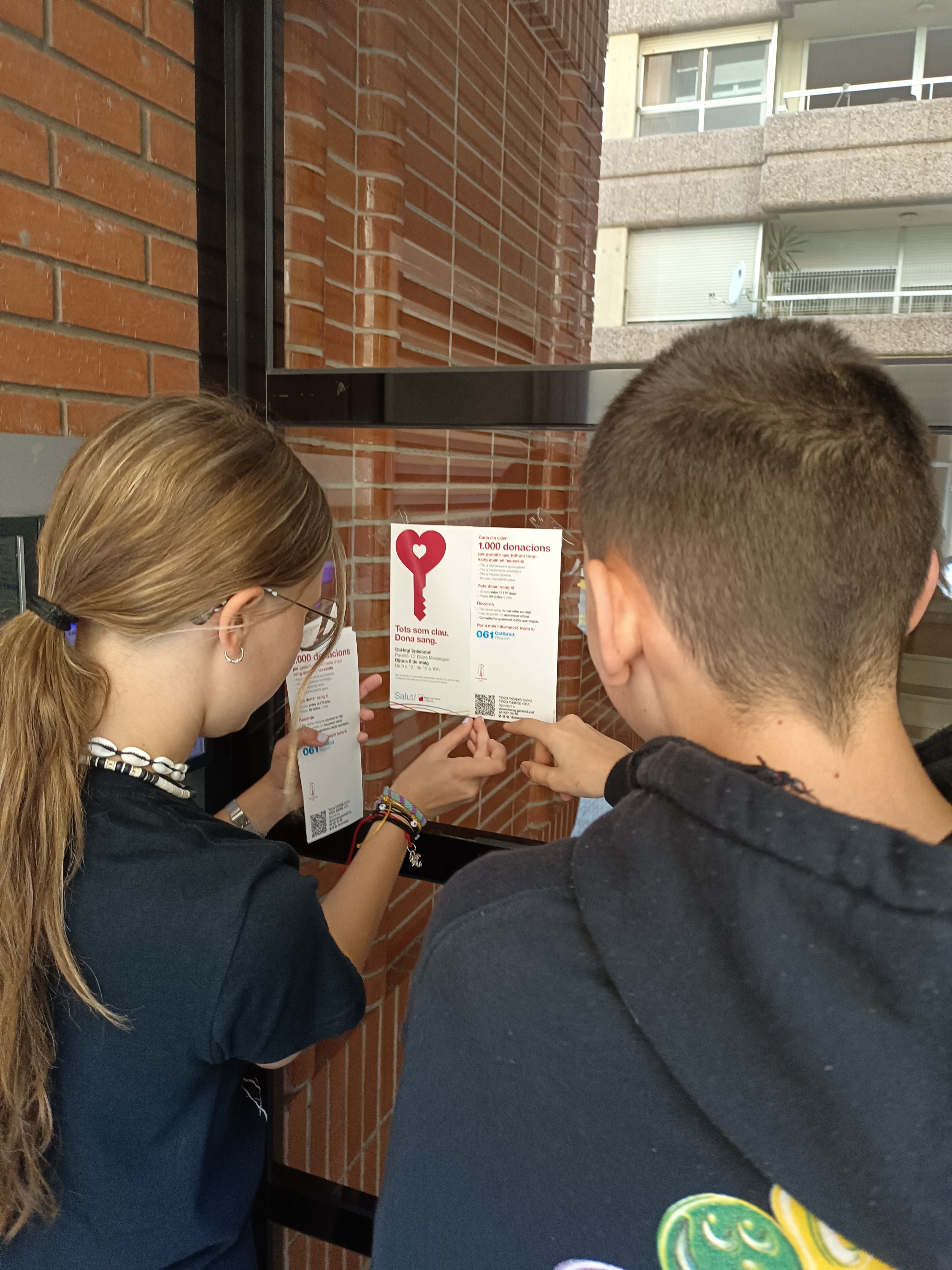 Alumnes penjant r&egrave;tols pel barri