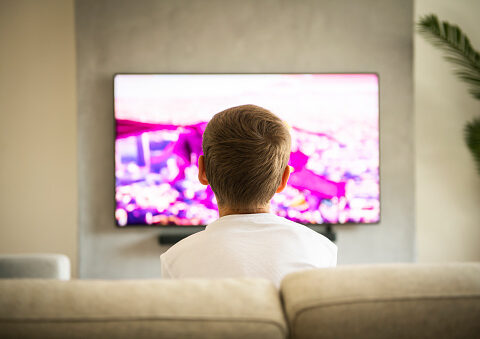 Un nen veient la televisió (Unsplash)